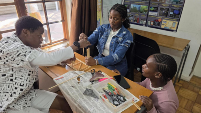 Students designing and building their model bridge with wooden sticks during the SAICE Bridge Building workshop