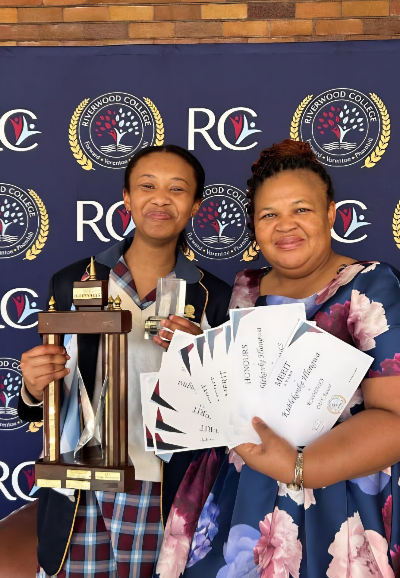 Kuhlekonke Hlongwa with her mother, holding her trophy and certificates