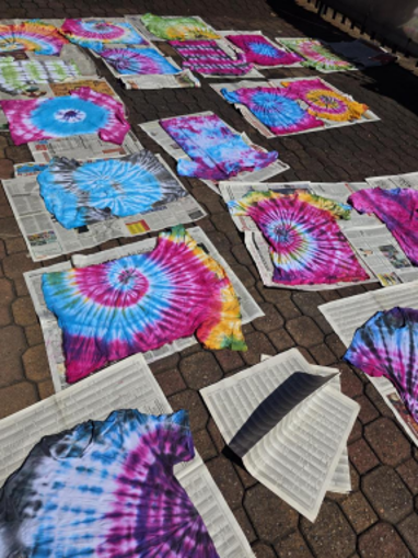 A colourful display of tie-dye T-shirts created by Grade 10 students, drying on newspaper